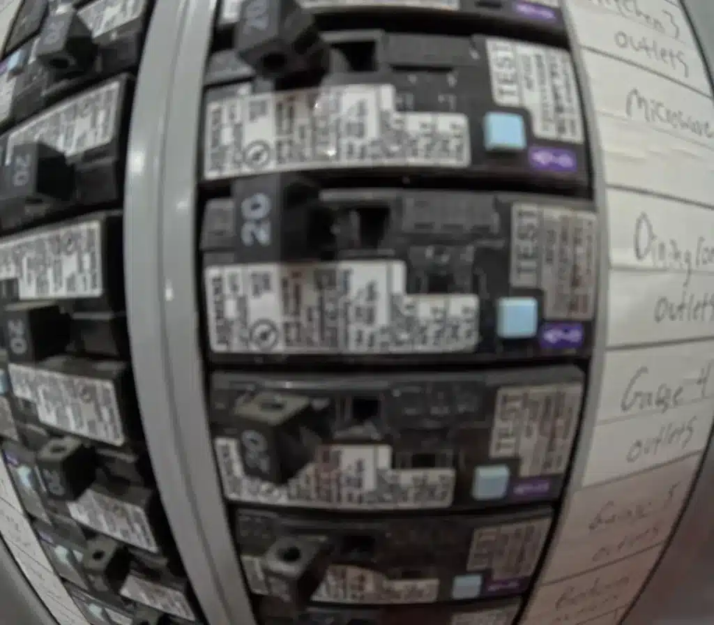 Electrical panel with circuit breakers labeled for various outlets and appliances, illustrating surge protection installation and maintenance for Iowa homeowners.
