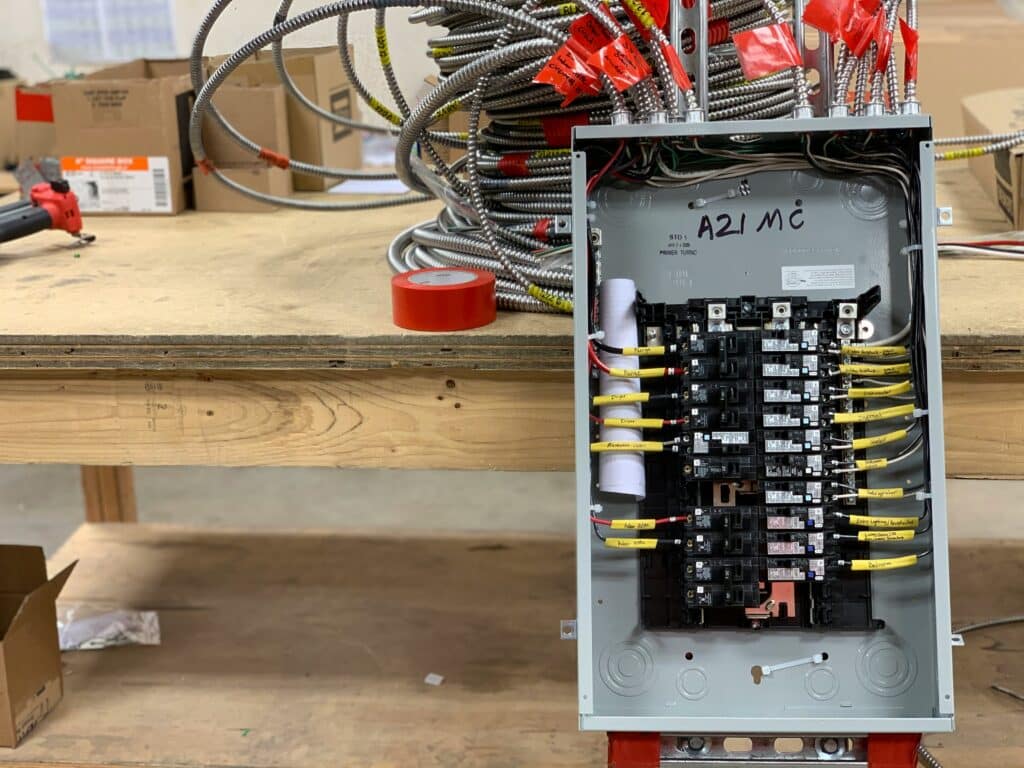 Electrical panel with circuit breakers and wiring, showcasing surge protection components and installation context for homeowners.